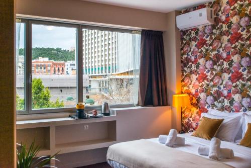 een hotelkamer met 2 bedden en een raam bij Athens Gem2 in Athene