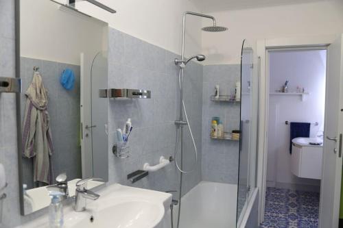 La salle de bains est pourvue d'une douche et d'un lavabo. dans l'établissement "Erica" Luminoso Trilocale sul Mare, à Anzio