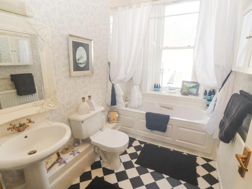 a white bathroom with a sink and a toilet and a tub at 3 Forest House in Penrith
