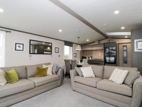 a living room with two couches and a kitchen at Tiggywinkles in Chipping Norton