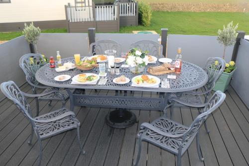 a table with plates of food on a deck at Tiggywinkles in Chipping Norton