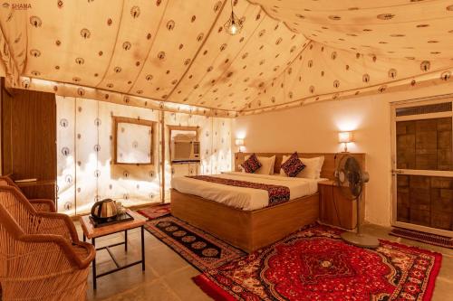 a bedroom with a bed and a chair in a room at Shama Desert Luxury Camp & Resort in Jaisalmer