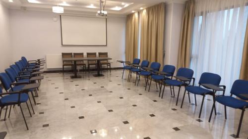 a room with chairs and a table and a whiteboard at Hotel Sarmis in Deva