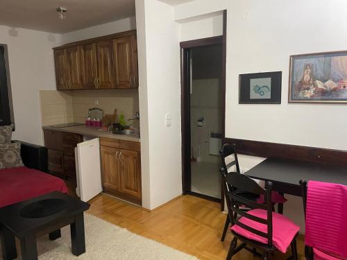 a kitchen with a table and chairs and a kitchen with a sink at Vila Zabac - Ski Center Tornik in Zlatibor