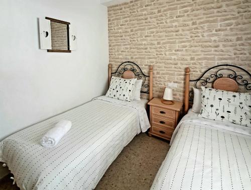 2 letti posti uno accanto all'altro in una camera da letto di Apartamento Rural El Bandolero a El Bosque