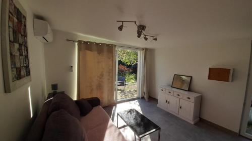 un salon avec un canapé et une fenêtre dans l'établissement Studio climatisé indépendant de 24m², à Calvi