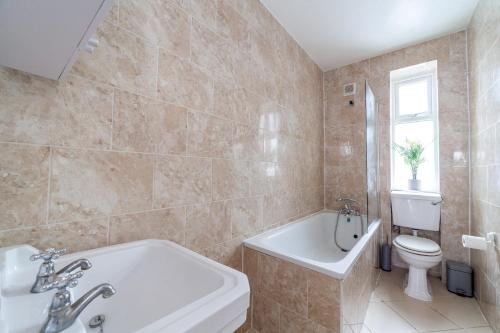 a bathroom with a tub and a toilet and a sink at The Angel Collection in London