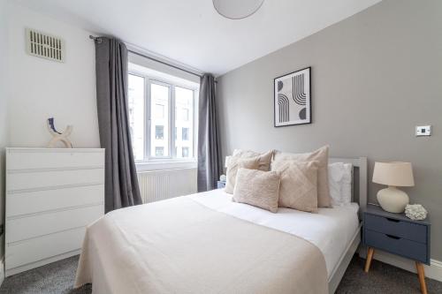 a bedroom with a white bed and a window at The Angel Collection in London