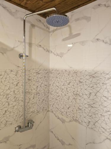 a bathroom with a shower with white marble walls at Sama Rum Camp in Wadi Rum