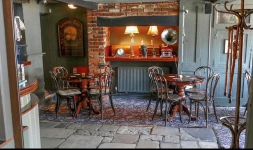a dining room with tables and chairs and a fireplace at Wheatsheaf Hotel in Newport