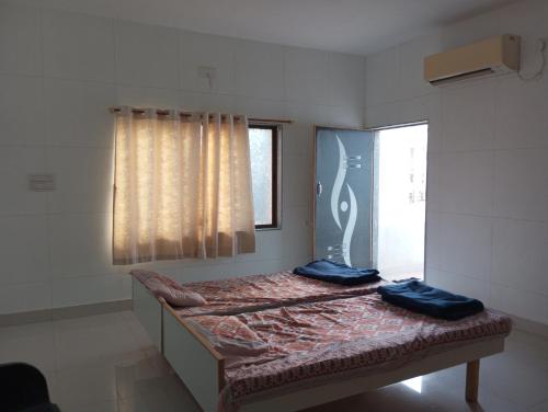 um quarto com uma cama com duas almofadas azuis em DWARKA BUNGALOW Only Family Full Bungalow em Dwarka