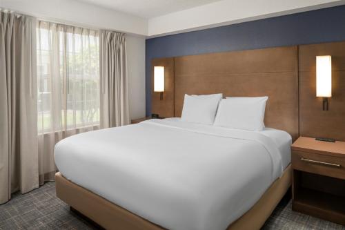 een groot wit bed in een hotelkamer bij Residence Inn by Marriott Orlando East/UCF Area in Orlando