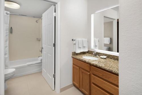 a bathroom with a sink and a toilet and a mirror at Residence Inn by Marriott Orlando East/UCF Area in Orlando