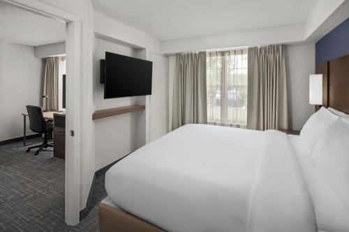 a hotel room with a bed and a television at Residence Inn by Marriott Orlando East/UCF Area in Orlando