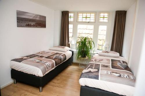 2 camas en una habitación con 2 ventanas en De Oude Zeilmakerij, groot, sfeervol vakantiehuis., en Woudsend