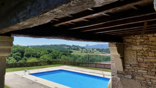 a swimming pool in a building with a stone wall at Pazo de Bendoiro in Bendoiro