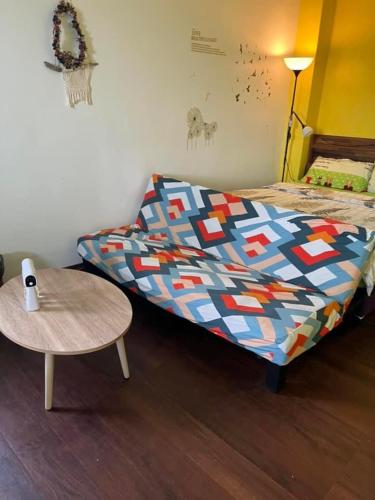 a bed with a colorful comforter and a table at Haven Seaview Homestay in Lanyu
