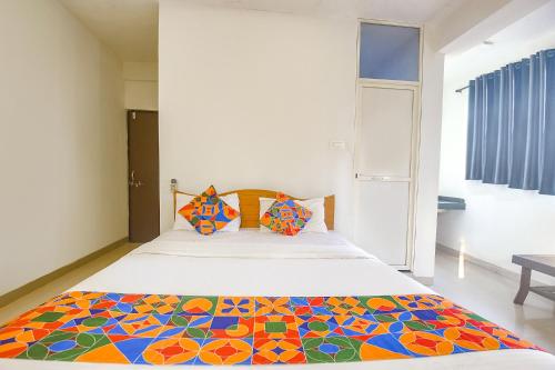 a bedroom with a bed with a colorful quilt on it at FabExpress Morjim Sea Waves in Old Goa
