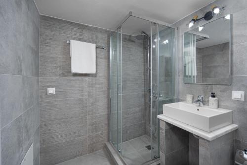 a bathroom with a sink and a glass shower at Michalis Home in Serifos Chora