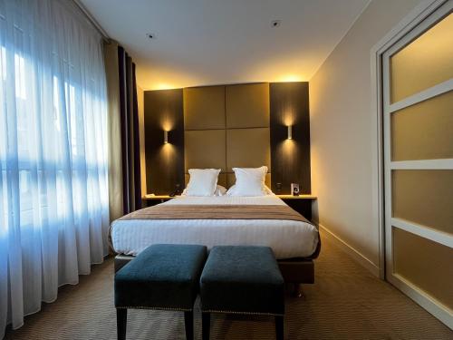 Una cama o camas en una habitación de LOGIS Hôtel Borel