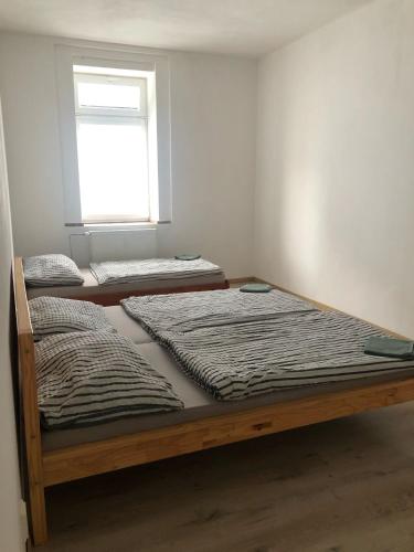 three beds in a room with a window at Apartmány Pražská in Ústí nad Labem