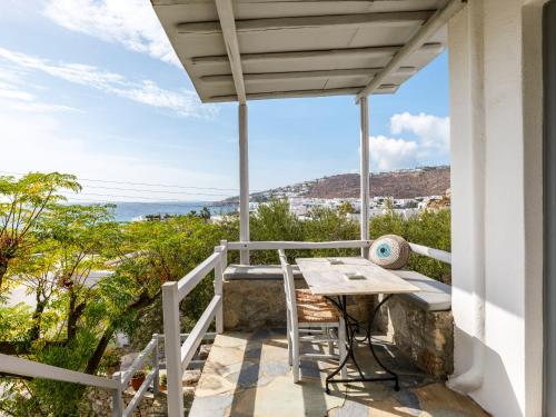 balcón con mesa y vistas al océano en BayBees Sea View Residence en Platis Gialos