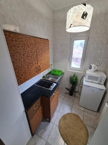 a small kitchen with a sink and a microwave at Tom Apartmans in Siófok