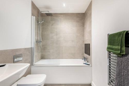 a bathroom with a tub and a toilet and a sink at Luxurious 3-Bed Penthouse in Sheffield in Handsworth