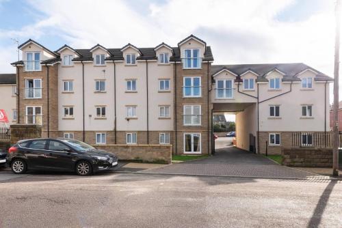 a black car parked in front of a large building at Luxurious 3-Bed Penthouse in Sheffield in Handsworth