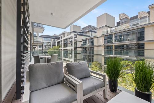 a balcony with two chairs and a view of a building at Spacious 2 Bedroom Luxury Apartment, City Walk Dubai in Dubai