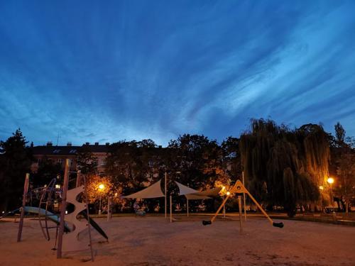 a playground at night with lights in a park at Green Park Rooms Brno in Brno