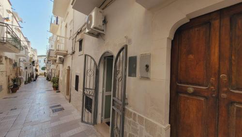 an alley in an old town with a wooden door at Casa Laura in Vieste