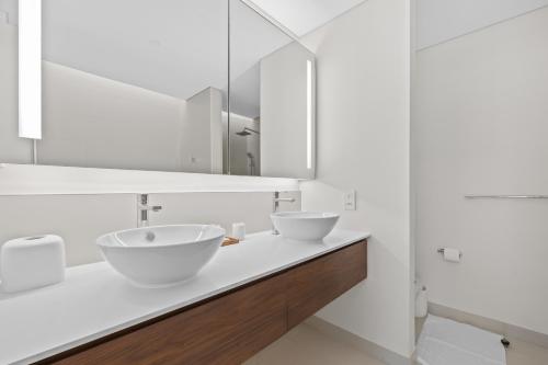 a white bathroom with two sinks and a mirror at Brand New Spacious 2 Beds City Walk B9 in Dubai
