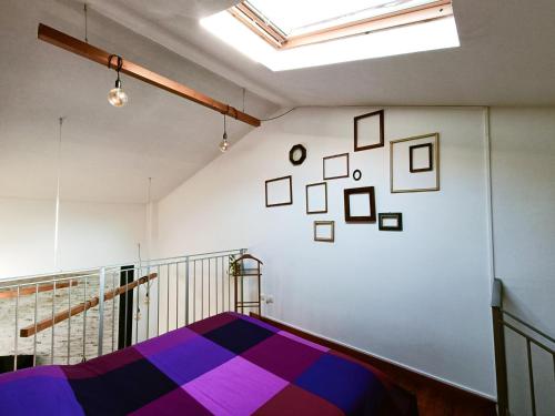 a bedroom with a purple bed and a white wall at Il loft di Nina in Florence