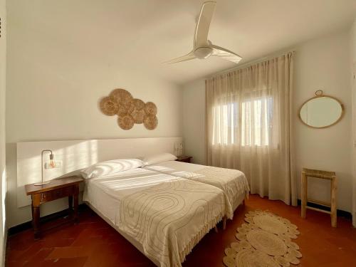 a bedroom with a bed and a ceiling fan at MASIA CENTENARIA EN SITGES in Sitges