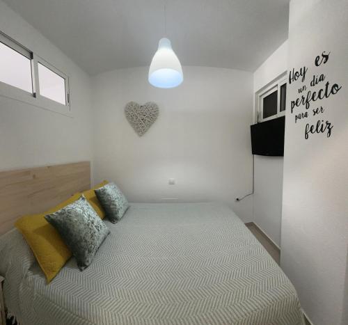 um quarto com uma cama e um coração na parede em apartamento torrequebrada em Benalmádena