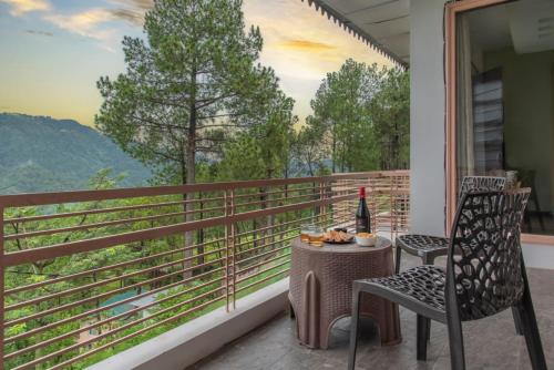 a table and chairs on a balcony with a bottle of wine at Host Jatin Kasauli Pine Villa 7oI827o7o3 in Kasauli