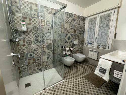 a bathroom with a shower and a toilet and a sink at VILLA TARA in Quercianella