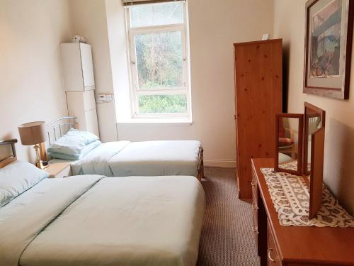 a room with two beds and a window at Glen Self-catering Apartment in Port Glasgow