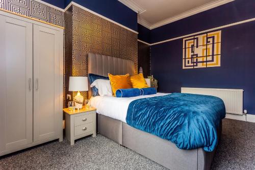 a bedroom with blue walls and a bed with a blue blanket at Room 03 - Sandhaven Rooms Double in South Shields