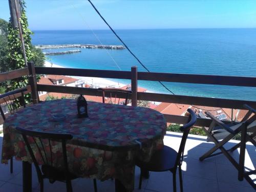 a table on a balcony with a view of the ocean at Irida Maria in Agios Ioannis Pelio