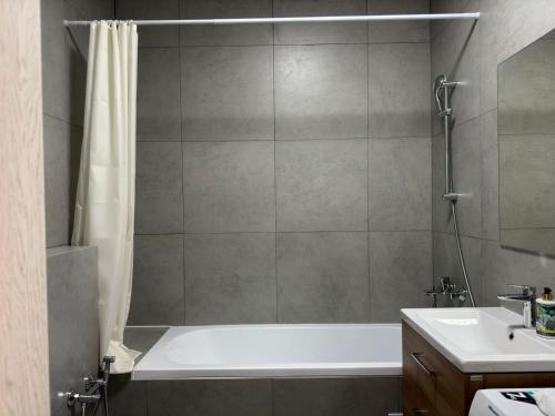 ein Badezimmer mit einer Badewanne und einem Waschbecken in der Unterkunft Апартаменты бизнес-класса в ЖК 4YOU in Almaty