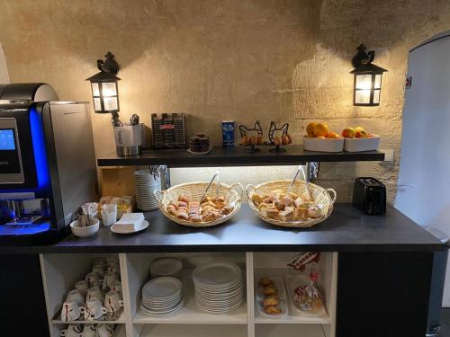 un comptoir avec trois paniers de denrées alimentaires et de assiettes dans l'établissement Hôtel Apollo Opéra, à Paris