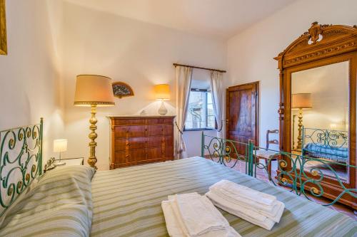 a bedroom with a bed with two towels on it at Chianti Classico Home Panoramic View - Happy Rentals in Castellina in Chianti