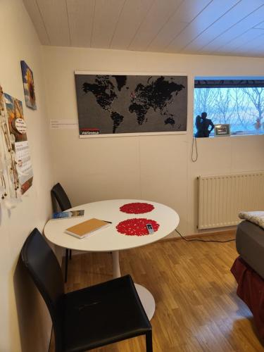 a room with a table and a map on the wall at Pokój z prywatną łazienką i kuchnią z hot pot in Keflavík