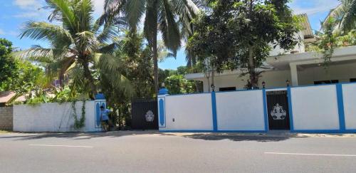 uma cerca azul e branca em frente a uma casa em Villa Ocean Breeze em Ambalangoda