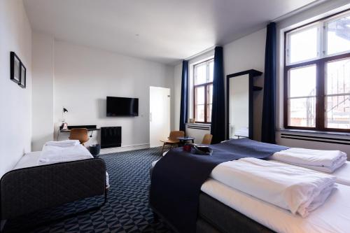 a hotel room with two beds and a television at Milling Hotel Ritz Aarhus City in Aarhus