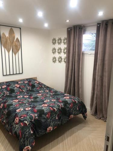 une chambre avec un lit avec un couvre-lit fleuri dans l'établissement Appartement RDC dans une Villas, à Montpellier