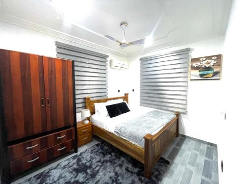 a bedroom with a bed and a large window at Kemc Apartment in Ashalebotwe