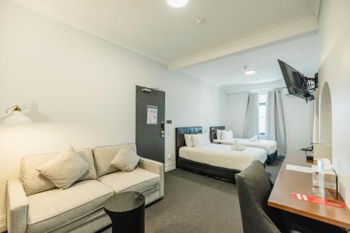 a living room with a couch and a bed at Newtown Cozy Stays in Sydney